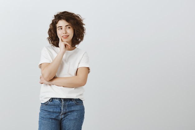 Fille souriante réfléchie à la ruse à droite, avoir une idée intéressante