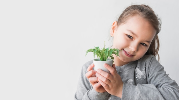 Fille souriante tenant une plante
