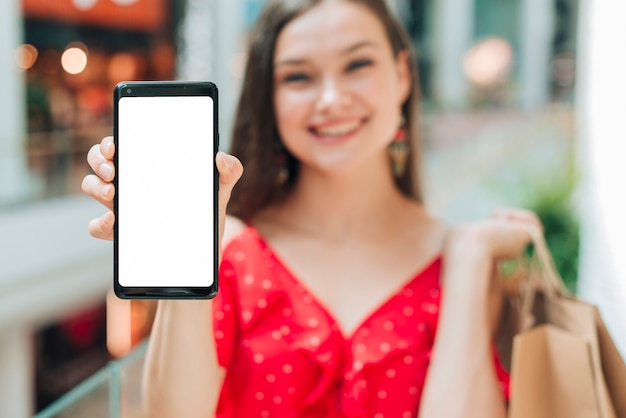 Fille souriante tenant son téléphone