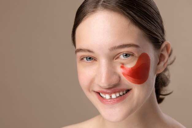 Fille souriante vue de côté posant avec cache-oeil