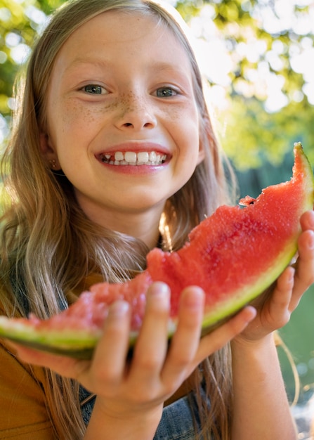 Fille souriante vue de face avec pastèque