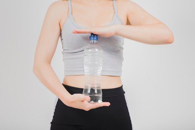 Fille sportive tenant une bouteille d&#39;eau