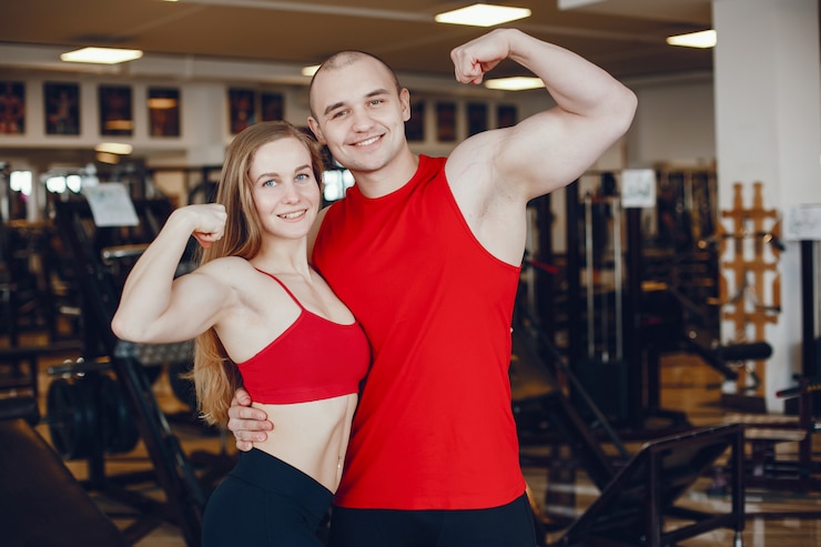 Photo gratuit une fille de sportswear belle et athlétique s&#39;entraînant dans la salle de gym avec un ami