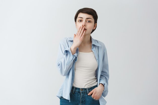 Fille surprise haletant et couvrant la bouche étonnée