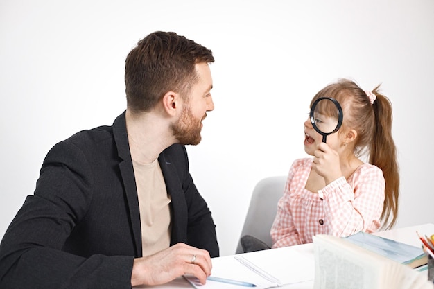 Fille avec le syndrome de Down étudiant avec son professeur à la maison