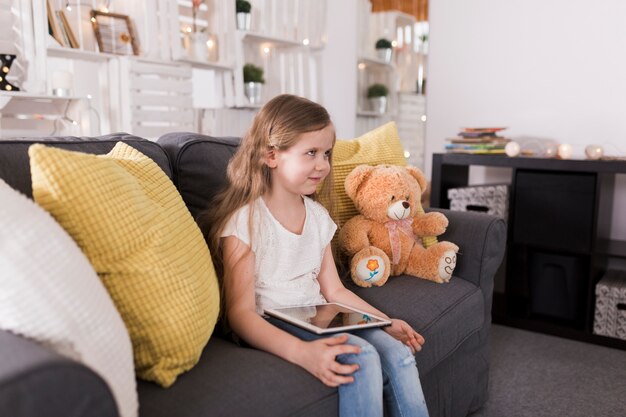 Fille avec tablette dans le salon