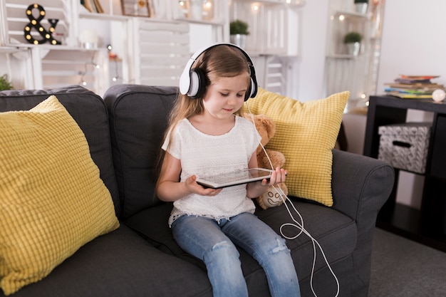 Fille avec tablette et écouteurs