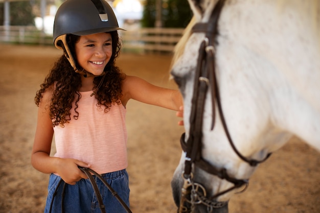 Photo gratuite une fille de taille moyenne avec un beau cheval.