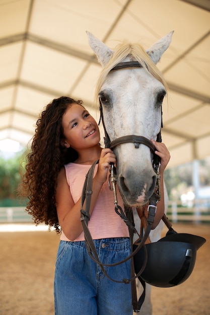 Photo gratuite une fille de taille moyenne avec un beau cheval.