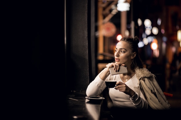 Fille avec téléphone la nuit