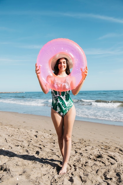 Photo gratuite fille tenant une bague gonflable à la plage