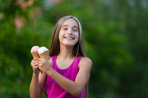 Fille tenant des cornets de glace dans le parc