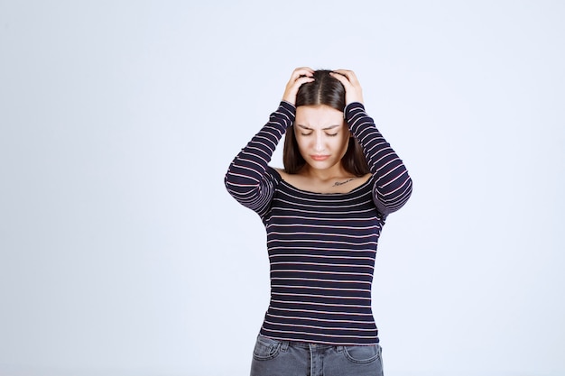 Fille tenant sa tête car elle est fatiguée ou a mal à la tête.