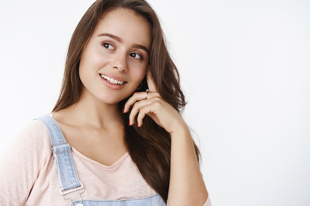 Fille tendre rêveuse pensant et ayant quelque chose de mignon et de bon à l'esprit souriant