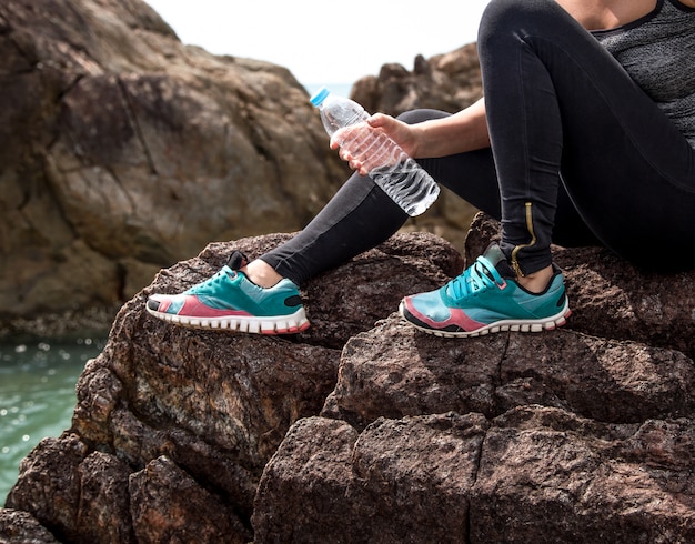 fille en tenue de sport sur les rochers