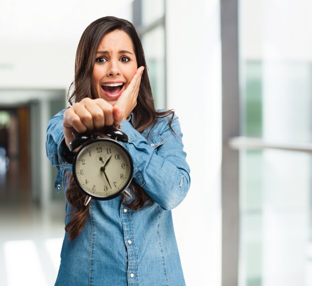 fille Terrifié tenant une horloge