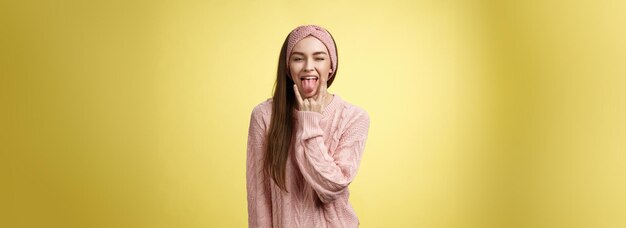 Photo gratuite une fille timide et bête ayant un cœur rebelle à l'intérieur montrant un geste rock'n'roll qui ressort