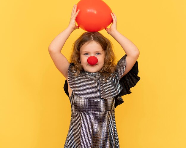 Fille de tir moyen portant le nez de clown