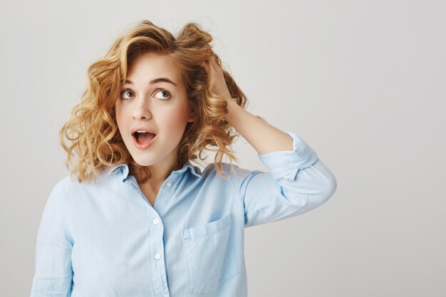 Fille de toucher les cheveux bouclés, décider d'aller coiffeur