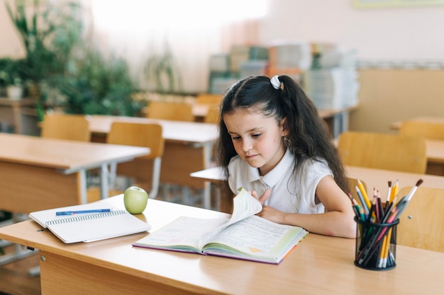 Fille tournant la page en classe