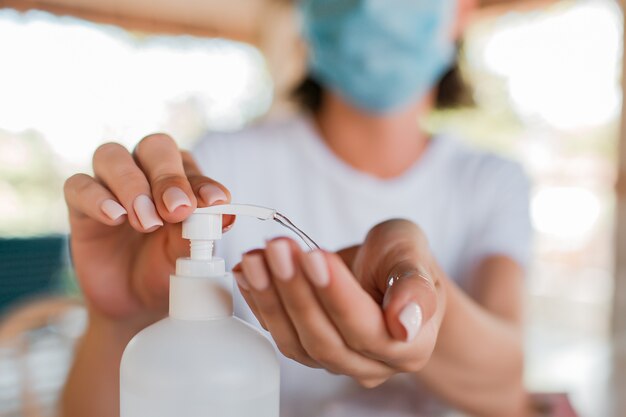 Fille traite ses mains avec des antisuptiques. Photo de haute qualité