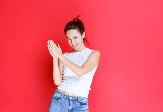 Fille unissant les mains et priant pour quelque chose.