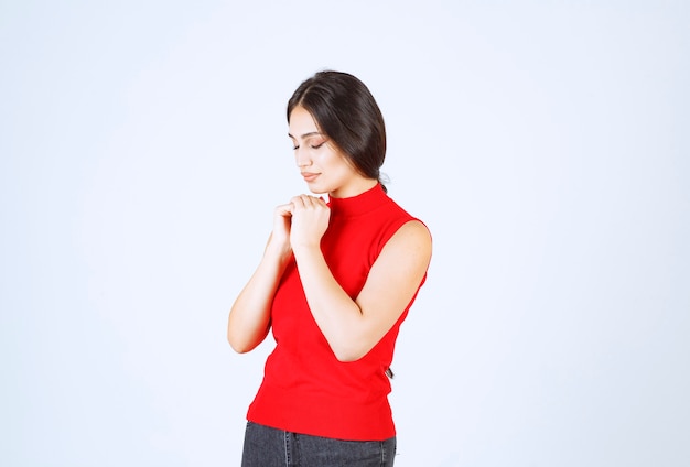 Fille unissant ses mains et demandant quelque chose.