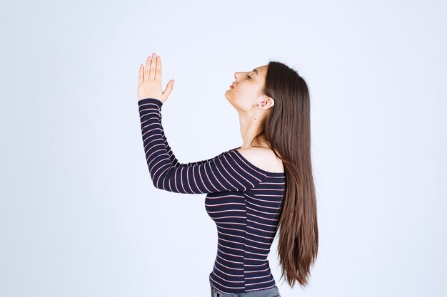 Fille unissant ses mains et priant.