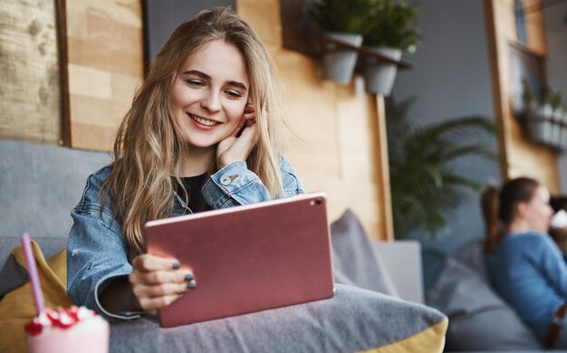 Fille urbaine se reposant dans un café parlant sur un téléphone portable et regardant