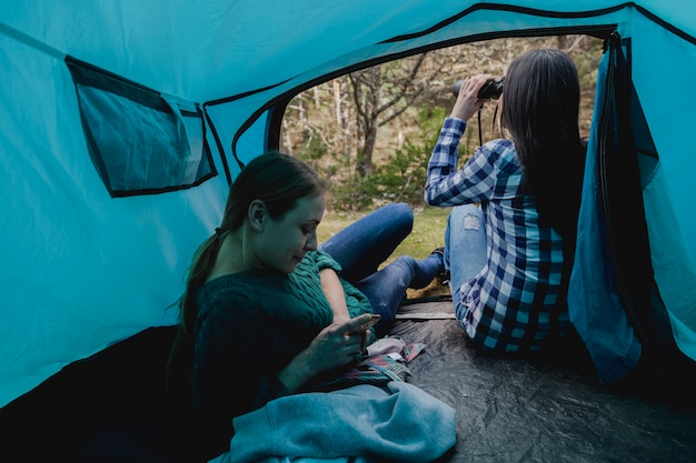 Fille utilisant ses jumelles à côté de son amie