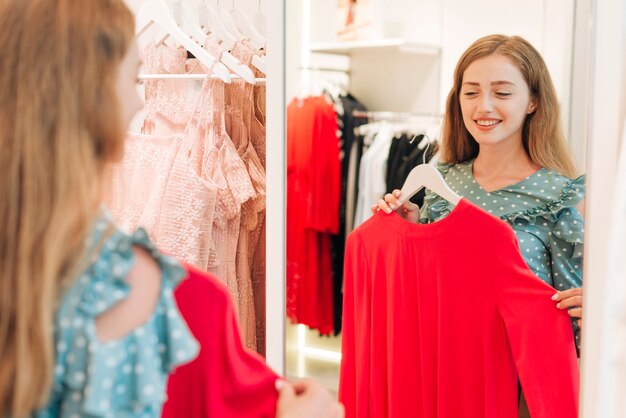 Fille vérifiant blouse dans le miroir