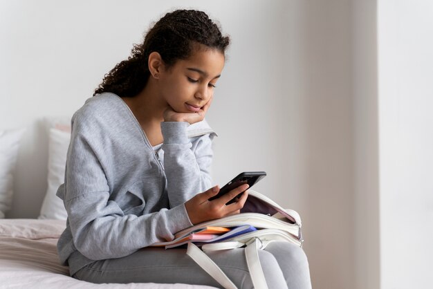 Photo gratuite fille vérifiant son téléphone avant l'école