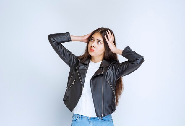 La fille en veste de cuir a l'air fatiguée et épuisée.