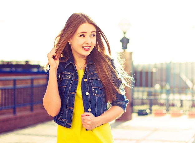 Fille avec la veste en jean toucher ses cheveux