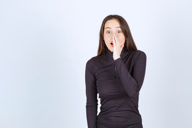 Fille en vêtements noirs faisant des potins.