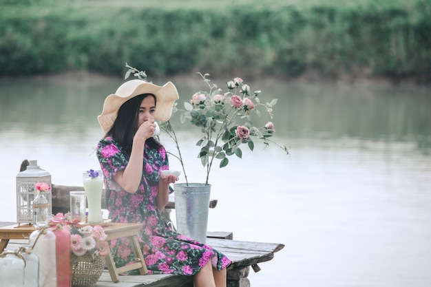 Fille vêtue d'une robe à fleurs assis au bord de l'eau