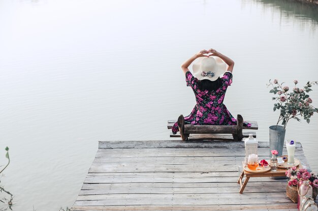 Fille vêtue d'une robe à fleurs assis au bord de l'eau