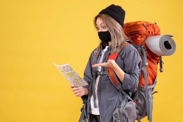 fille de voyageur avec masque noir et sac à dos regardant la carte