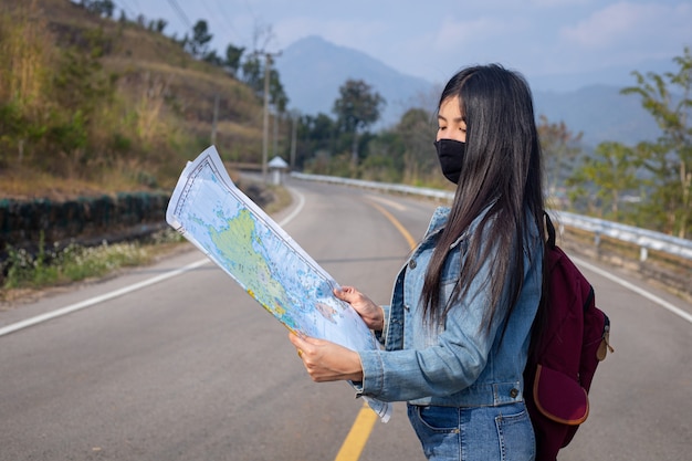 Fille de voyageur recherchant la bonne direction sur la carte