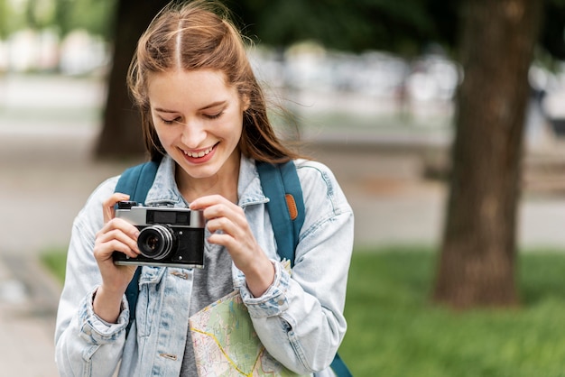 Fille de voyageur Smiley et appareil photo rétro