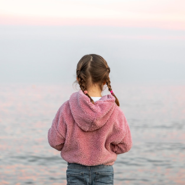 Fille de vue arrière au bord de la mer