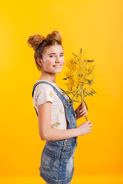 Fille vue de côté avec des branches de fleurs