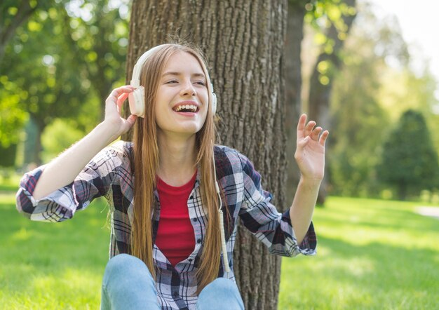 Fille vue de face, écouter de la musique en plein air