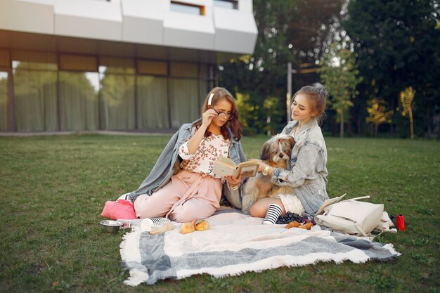 Filles assises sur une couverture dans un parc d'été