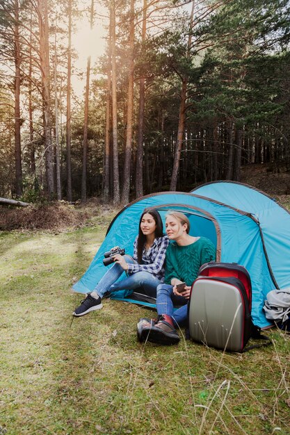 Filles assises dans la tente au coucher du soleil