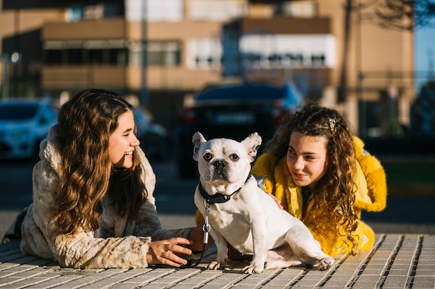 Photo gratuite filles avec un chien dans la rue