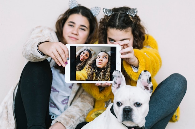 Filles avec un chien et une tablette