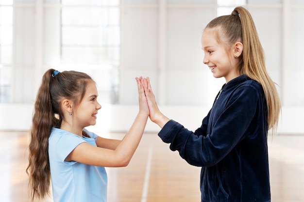 Filles à coup moyen jouant au gymnase