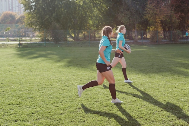 Filles courir avec un ballon de rugby
