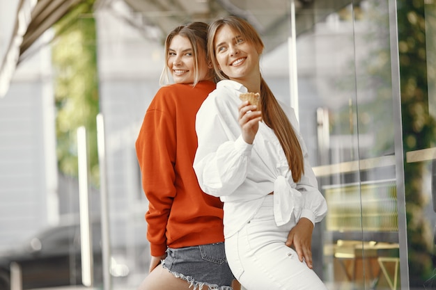 Filles debout dans une ville d'été avec de la glace